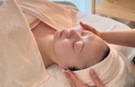 木更津のアロマサロンにて、石鹸洗剤で洗い上げた柔らかなガーゼのリネンに包まれ、オールハンドのフェイシャル施術を受けている写真。心身の緊張がゆるやかに解けていく休息のひととき。